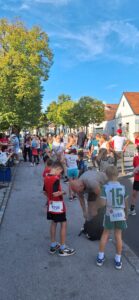 Kinder beim Lauf in Österreich, mit Startnummern und sportlicher Kleidung, bereit für den Wettkampf.